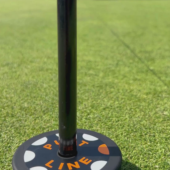 Putt Line Two-Way Putting Practice System with Straight Line String Line Set up in the middle of the frame with a golfer putting directly towards the camera to hit the straight line towards the visual rubber puck in the foreground of the frame. 